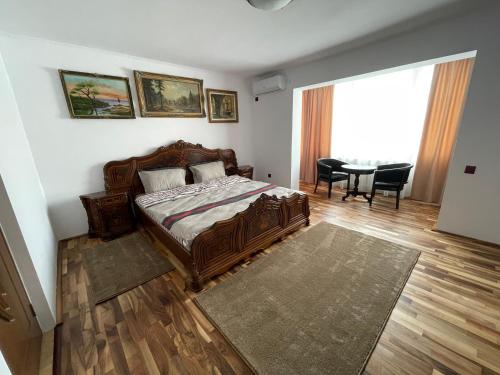 a bedroom with a bed and a table with chairs at M & I Apartment 3 in Târgu-Mureş