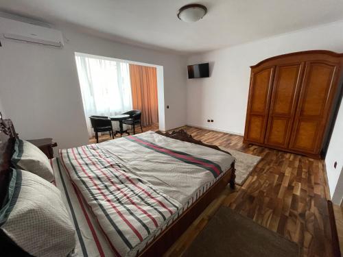 a bedroom with a bed and a dresser and a table at M & I Apartment 3 in Târgu-Mureş