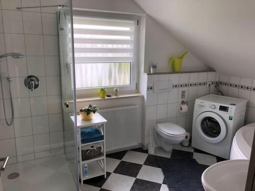 uma casa de banho com um WC e uma máquina de lavar roupa em Ferienwohnung Anita em Jandelsbrunn