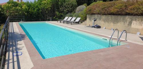 een zwembad met 2 ligstoelen ernaast bij Moderne Villa mit atemberaubendem Seeblick in Lisciano Niccone