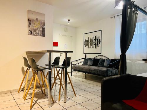 a living room with a table and chairs and a couch at Charmant studio proximité centre-ville et gare in Châlons-en-Champagne