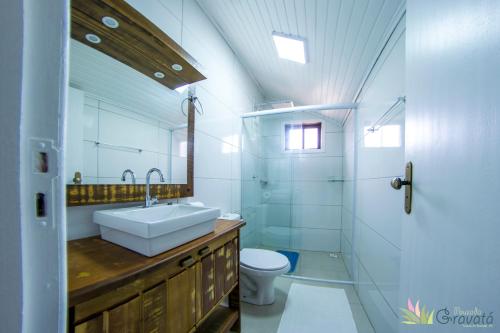uma casa de banho com um lavatório, um WC e um espelho. em Pousada Gravatá em Gravatal