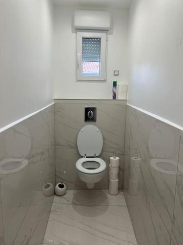 a bathroom with a toilet and a window at Joli appartement in Blanzy