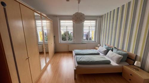 Zimmer mit einem Bett und 2 Fenstern in der Unterkunft Ferienwohnung am Bodetal mit Wallbox für E-Auto in Thale