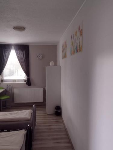 a room with two beds and a white refrigerator at Pension Novy Den in Albrechtice