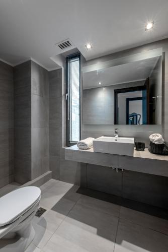 a bathroom with a sink and a toilet and a mirror at Villa Soligia Thalassa in Pefkali