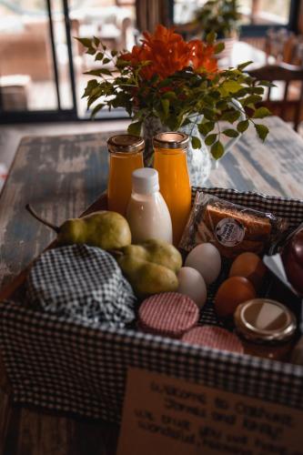 een mand met eieren en een vaas met bloemen op een tafel bij Oakhurst Farm Cottages in Wilderness