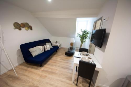 ein Wohnzimmer mit einem blauen Sofa und einem Tisch in der Unterkunft MALËiKA !!! Superbe T2 HOME STAGING avec parking gratuit !!! in Saint-Quentin