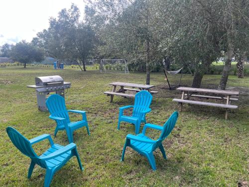 a group of blue chairs and picnic tables in a park at The Perfect Get Away !!!! in Clewiston
