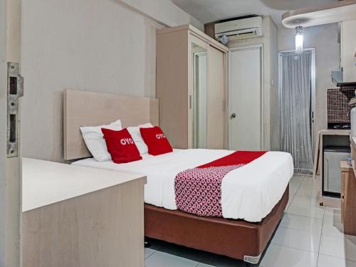 a bedroom with a bed with red pillows at Capital O 91820 S&a Collection 2 in Jakarta