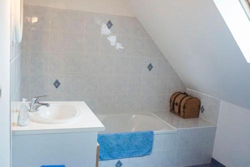 a bathroom with a sink and a bath tub at Les Hortensias, Maison 8 personnes, proche mer, Le Pouldu in Clohars-Carnoët