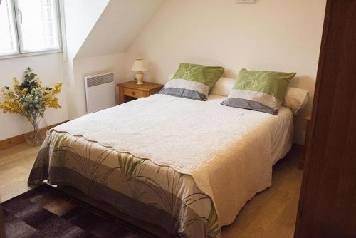 - une chambre avec un grand lit et des oreillers verts dans l'établissement Les Hortensias, Maison 8 personnes, proche mer, Le Pouldu, à Clohars-Carnoët
