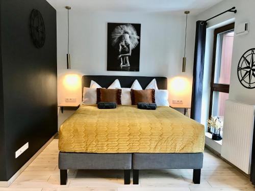 una camera da letto con un grande letto con lenzuola e cuscini gialli di Bookowska Dal Cuore Apartment a Poznań