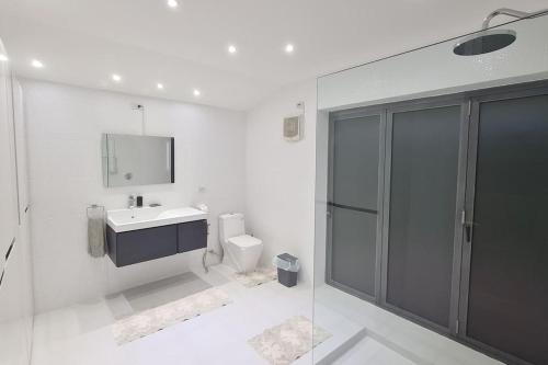 a white bathroom with a sink and a toilet at Lovely modern 2 bed villa in Pran Buri