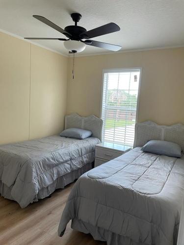 a bedroom with two beds and a ceiling fan at The Perfect Get Away !!!! in Clewiston