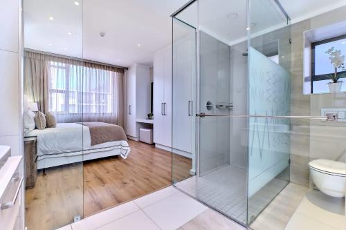 ein Bad mit einer Glasdusche und einem Bett in der Unterkunft La Vista Dream Apartments Luxury & Modern with City View and Inverter back up! in Johannesburg