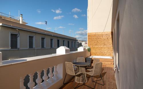 een balkon met een tafel en stoelen in een gebouw bij Praxitelous Luxury Suites in Athene
