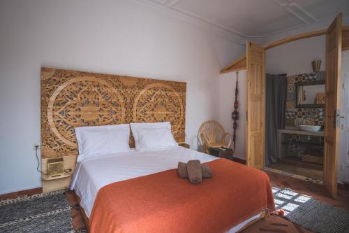 a bedroom with a large bed with an orange blanket at Riad Villa Berna under Swiss Management in Marrakesh