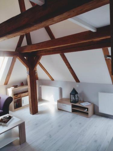 a living room with wooden ceilings and wooden beams at Pension Novy Den in Albrechtice