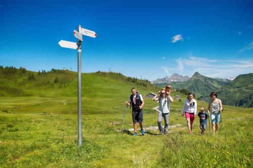 a group of people walking on a hill near a sign at Ferienwohnung Haus Annabelle Top 3 in Damuls