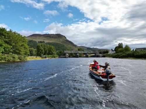 a group of people in a boat on a river at Loch Rannoch Highland Club in Kinloch Rannoch