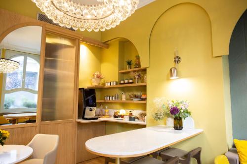 una sala da pranzo con tavolo e lampadario pendente di Hotel Louison a Parigi