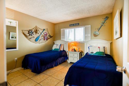 een slaapkamer met 2 bedden en blauwe dekbedden bij Ocean view condo in beachfront resort with WiFi, central AC, 2 pools, & tennis in St. Augustine