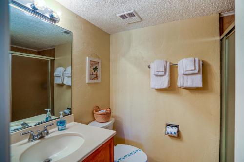 een badkamer met een wastafel, een toilet en een spiegel bij Ocean view condo in beachfront resort with WiFi, central AC, 2 pools, & tennis in St. Augustine