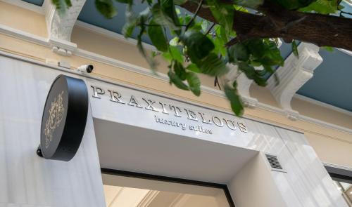 un cartello per l'ingresso di un edificio del Tesoro di Praxitelous Luxury Suites ad Atene