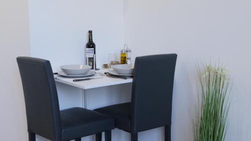 una mesa con dos sillas y una botella de vino en EMYSTA - CHARMANT Studio HOME STAGING en plein centre, en Saint-Quentin