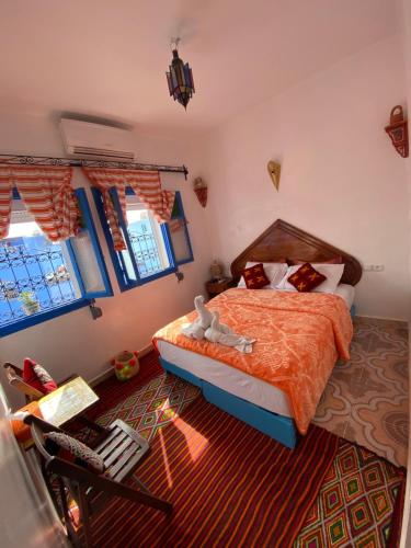 - une chambre avec un lit et une chaise dans l'établissement Riad sakura, à Chefchaouen