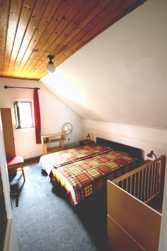 a bedroom with a bed and a wooden ceiling at Nefelejcs in Zamárdi