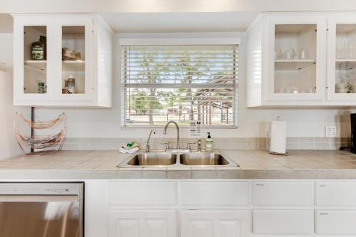 a white kitchen with a sink and a window at Green River Lodge - Lake LBJ in Burnet