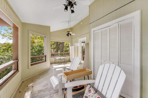 two white chairs and a table in a room with windows at Green River Lodge - Lake LBJ in Burnet