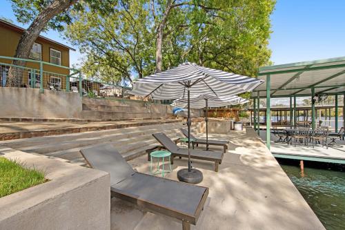 a patio with tables and chairs and an umbrella at Green River Lodge - Lake LBJ in Burnet