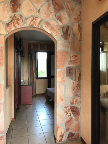 a hallway in a room with a stone wall at American Motel in Cisterna di Latina