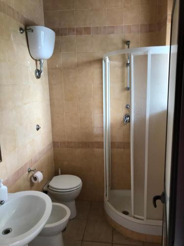 a bathroom with a shower and a toilet and a sink at American Motel in Cisterna di Latina