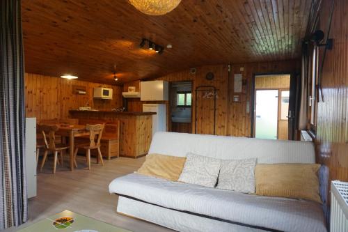 un salon avec un canapé et une cuisine dans l'établissement Le pavillon de l'étang, à Vagney