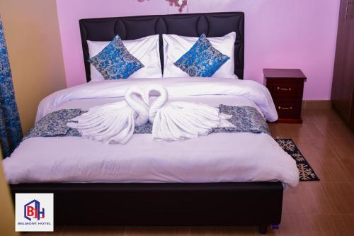 een slaapkamer met een bed met twee witte vleugels bij Belmont Hotel Homabay in Homa Bay