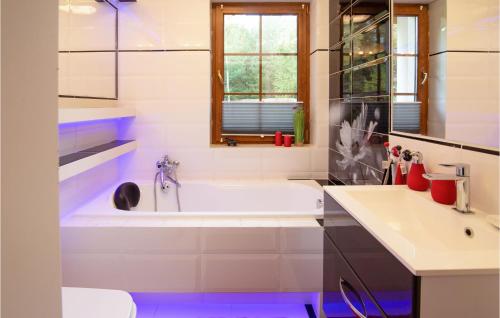 a white bathroom with a tub and a sink at 3 Bedroom Awesome Home In Ryn in Ryn