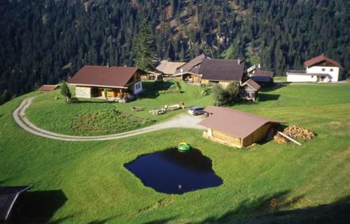 an aerial view of a house with a lake in the grass at Berghütte Graslehn in Jerzens