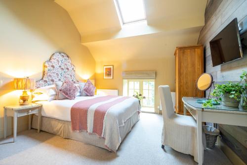 sypialnia z łóżkiem z krzesłem i telewizorem w obiekcie Gardeners Cottage w mieście Sandsend