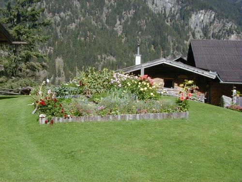 einen Garten vor einem Haus mit einem Berg in der Unterkunft Berghütte Graslehn in Jerzens