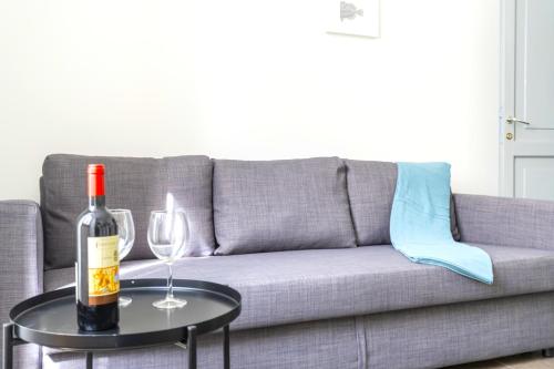 a bottle of wine on a table next to a couch at Hostly - Nicole Apartment Volturno- Full Rome Center in Rome