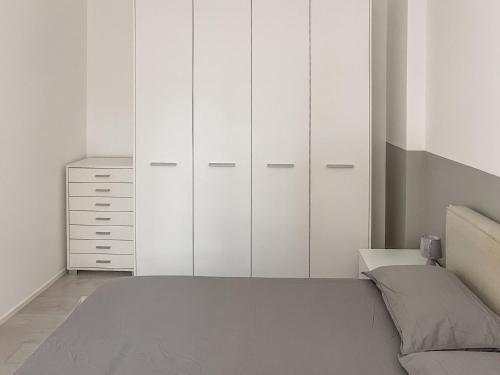 Schlafzimmer mit weißen Schränken und einem Bett in der Unterkunft BNB Capital Milano Moscova - White in Mailand