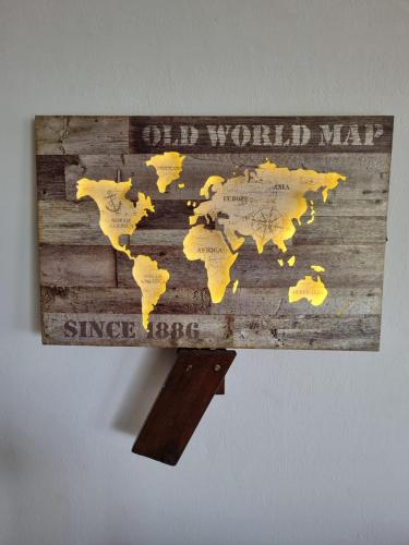 a wooden sign with a world map on it at Bujumbura Guest House in Port Edward
