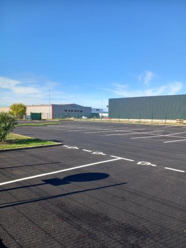 an empty parking lot with a building in the background at B&B HOTEL Agen Castelculier in Castelculier