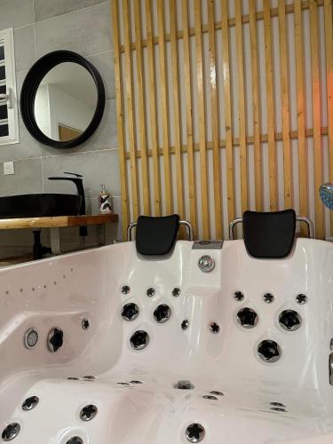a white bath tub with two chairs in a bathroom at La kazanou in Saint-Joseph
