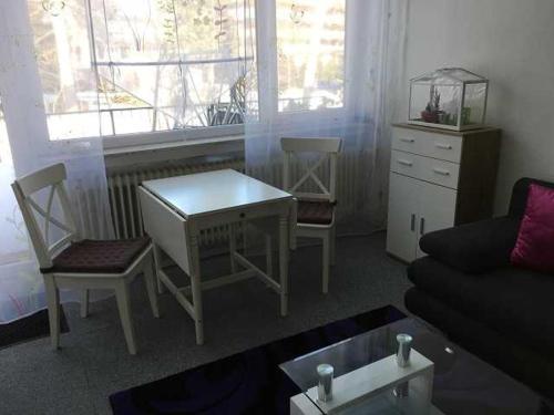 - un salon avec une table, des chaises et un canapé dans l'établissement Ferienwohnung Am Wald, à Schönwald