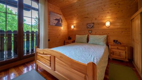 a bedroom with a bed in a log cabin at Chalet House Olga in Crni Lug
